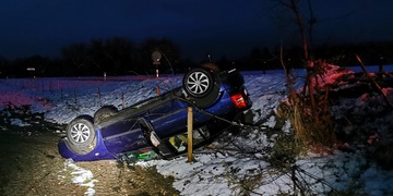 Řidič nezvládl řízení, smetl pomníček a s autem se v poli převrátil