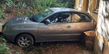 Špatně zabrzděné auto sjelo ze srázu, prorvalo si cestu křovinami a nabouralo do budovy